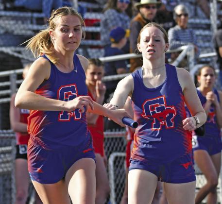 Photo by Melissa Grover Junior Rylie Barker hands off to teammate senior Natalie Popken during the 4x800 meter relay. The relay team would earn a second place medal in the event with a time of 11:09.05.