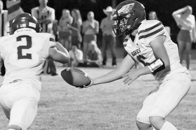 Photo by Harry Lipsiea, Keith County News Junior quarterback Jaydub Turman hands the ball off to senior Tripp Buettner. Buettner would rush for 187 yards this week and three scores but the Hawks fell short to Wallace, 50-22.