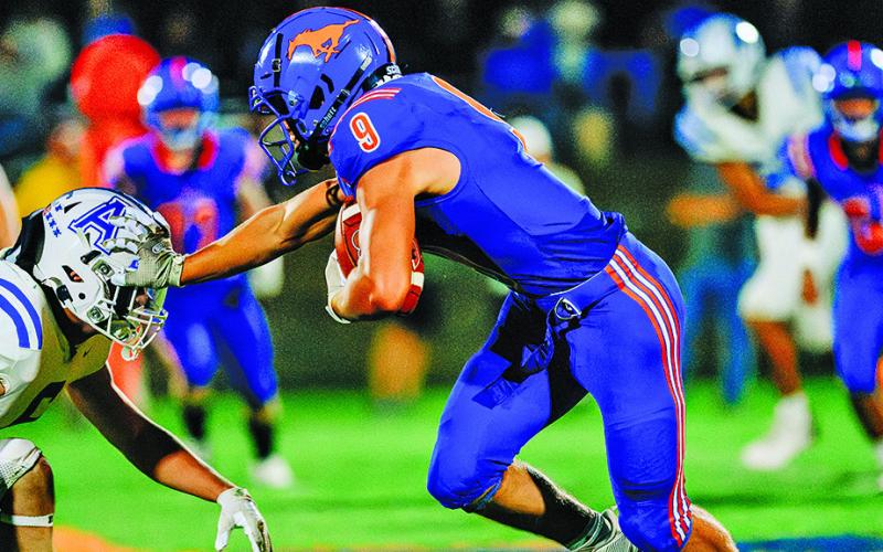 (Photo by Morgan Meisenheimer) Senior Daniel Martins applies the stiff arm to the helmet of the Alliance defender during the 2025 season.
