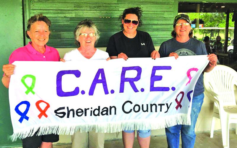 Courtesy Photo Marie Tystad, Joyce Benben, Brett Weaver, and Joni Elwood hold up the CARE sign after one of their signature golf tournaments at the Gordon Country Club. Tystad was the third founding member of the organization back in 2007 when it all began.