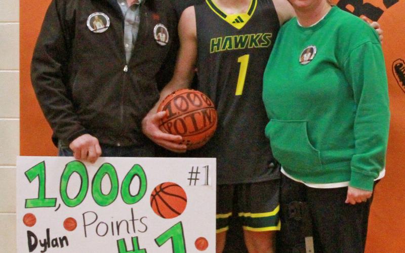 (Photo by Bev Lee) Adam and Jennifer Young take a photo postgame with their son, Dylan Young, following his scoring of his 1,000th career point as a Hawk.