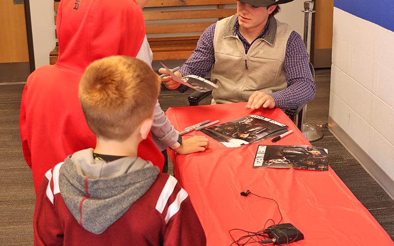 (Photo by Scott Bidroski) Young fans get their poster signed by Gordon native and Professional Bull Rider Conner Halverson on Wednesday, June 4 at the Gordon Theatre.