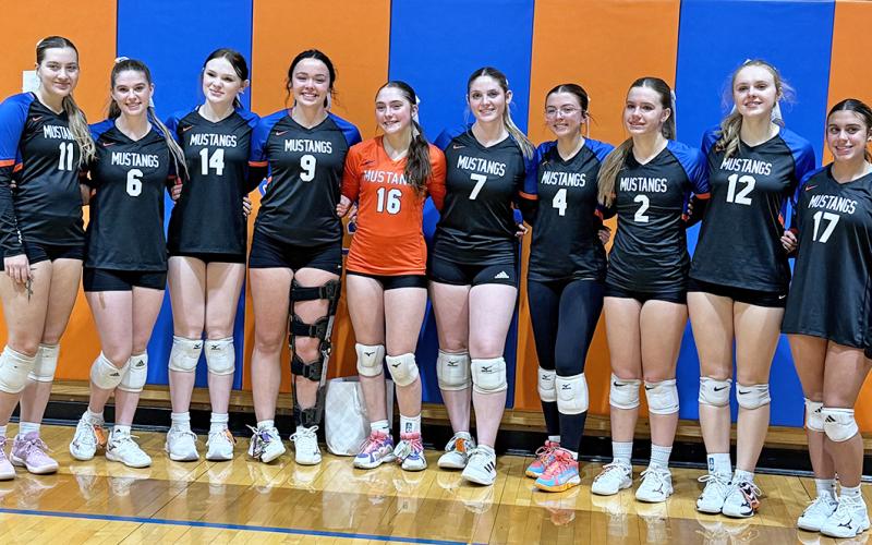 (Photo by Michele Heck) Ten seniors put on the orange and blue for the final time as Mustang Volleyball players. Here is the group pictured after their final home match.