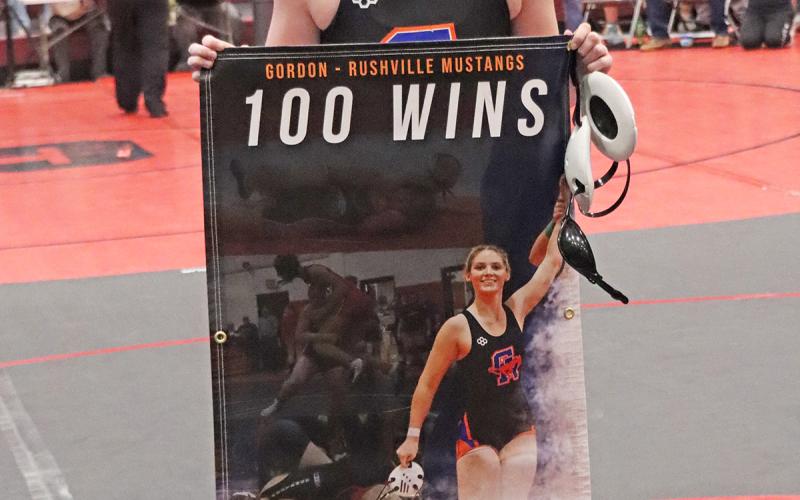 (Photo by Scott Bidroski) Kirsten Heck is all smiles following her 100th win on Saturday, January 24 in Chadron. Heck celebrated the occasion with a commemorative banner for the accomplishment.
