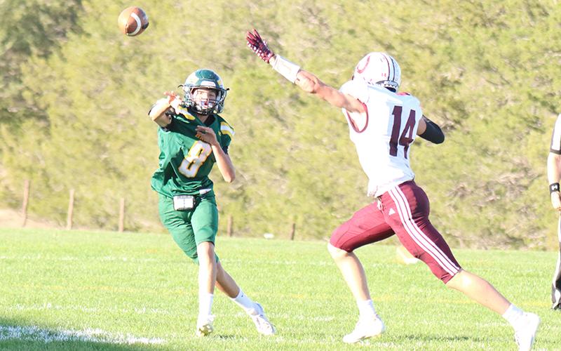 (Photo by Scott Bidroski) Ashton Raymer eludes the rush to deliver a pass against the Stuart Broncos.