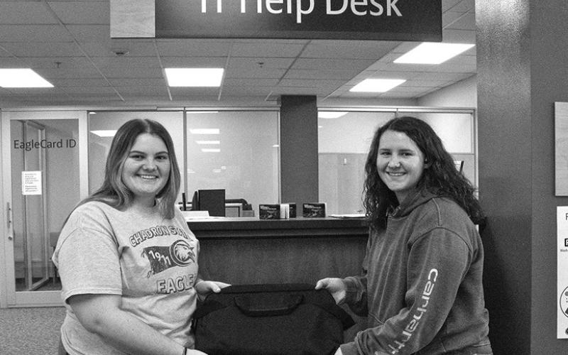 Photo by Tena L. Cook, CSC Chadron State College students Alivia Taylor, left, and Emmali Taylor, both of Beaver City, Neb., pose with a laptop by the IT Help Desk in the King Library.