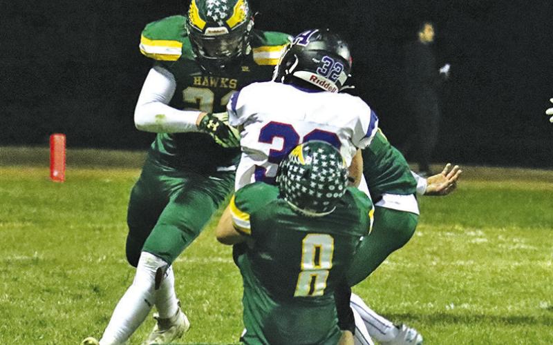 Photo by Scott Bidroski Hawk seniors Talan Smith (#21) and Hunter McDonald (#8) bring down an Arthur County ball carrier during the October 25 contest.