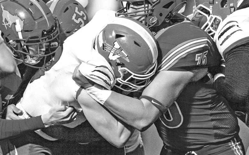 Photo by Morgan Meisenheimer Senior Lain Tausan wraps up the Badger ball carrier for a minimal gain.