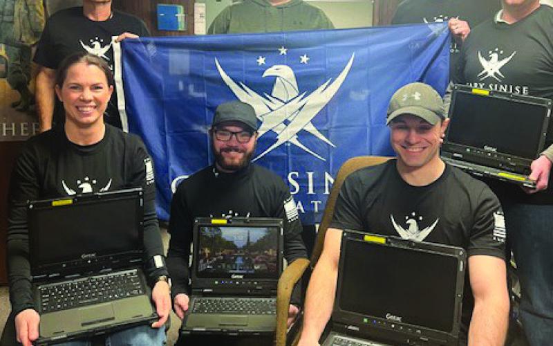 Courtesy Photo Police Chief Clay Heath holds banner for the Gary Sinise Foundation that helped provide funding for some of the new equipment recently purchased for the Gordon PD, including the new rugged G-tech laptops pictured here.