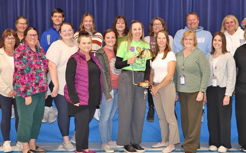 (Photo by Scott Bidroski) Gordon Elementary Principal Robin Johnson (center) takes a photo with her staff at Gordon Elementary on Monday, November 3. Johnson received the Lozier Foundation LIGHTS Outstanding Principal Award on Thursday, October 30 in Omaha. Johnson received $25,000 in monies to help improve GES along with a commemorative lamp, which is displayed above.