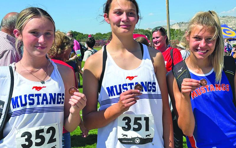 Photo by Amy Schmidt Some hardware came home on the Mustang bus following their races at Red Rocks Amphitheater in Gering, Neb. From left to right, Kynsleigh Krebs, Ashlyn Dehning, and Brittany Dehning all placed in the top ten during the days races.