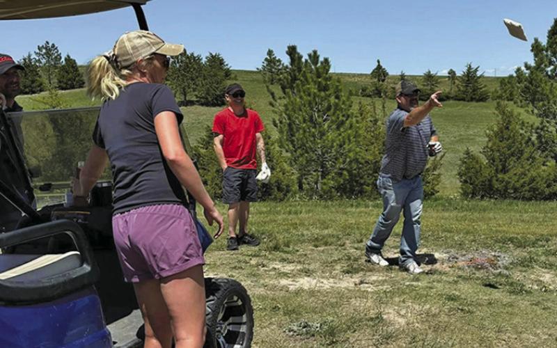 Photo by Lisa Merritt Brant Buettner, Lexi Buettner and David Galyen watch as Erik Persons tosses his cornhole bag at the Hay Springs Golf Course.