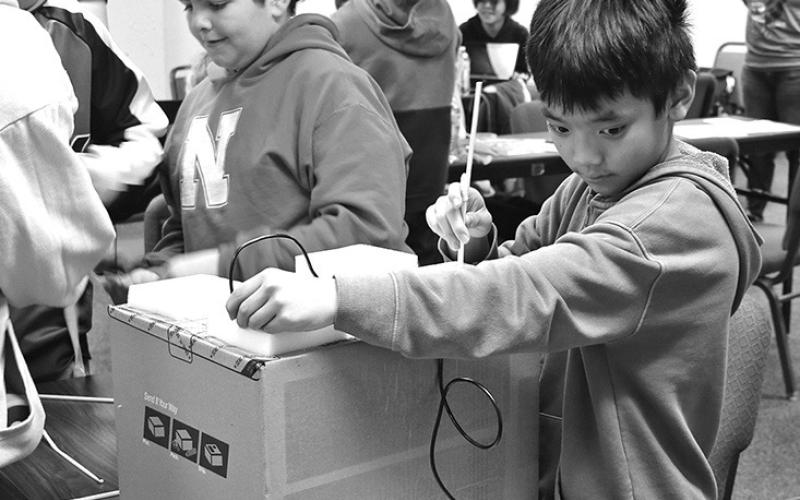 Photo by Chabella Guzman Performing laparoscopic surgery, Jackson Freeling, front right, keeps an eye on the screen to guide him. Meanwhile, Giovanni Gomez, back right, and others get their tools ready for surgery.