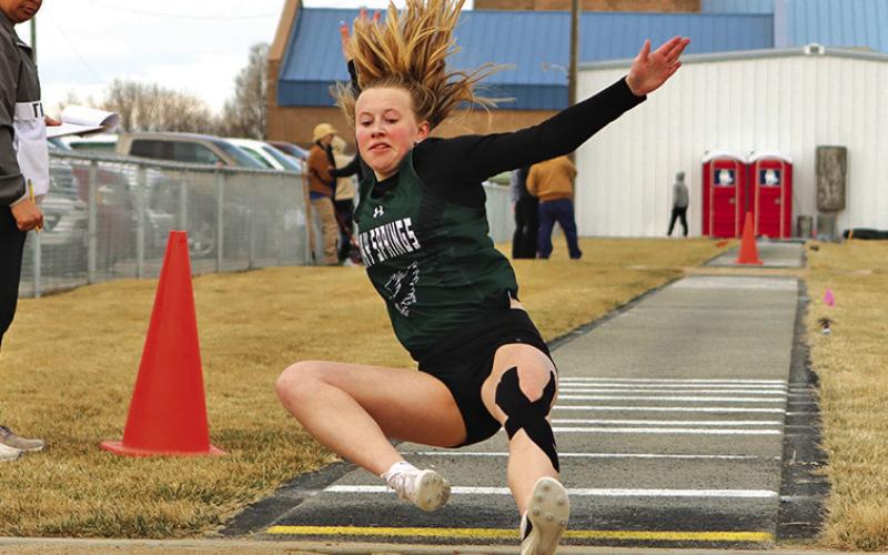 Photo by Scott Bidroski Freshman Reese Varvel slides into the landing pit during the Long Jump event in Bayard on March 28.