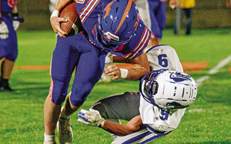 Photo by Morgan Meisenheimer Senior Kyler Vincent runs over a Gibbon defender en route to a big gain for the Mustangs. Vincent finished his evening with 124 yards and 2 touchdowns.