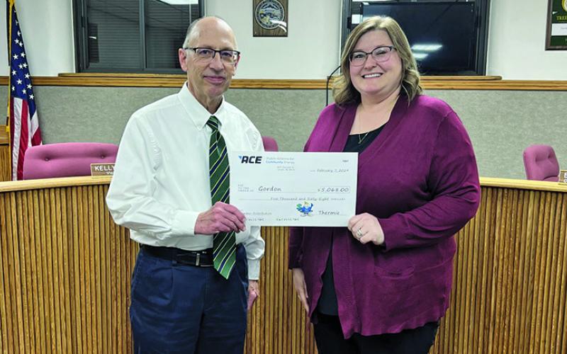Courtesy Photo City Manager Glen Spaugh (left) and Gordon City Council President Alyssa DeHart (right) present a check from (P)ACE’s annual distribution for the amount of $5,068. The monies from the distribution will go to installing an emergency exit on the west side of the Library.