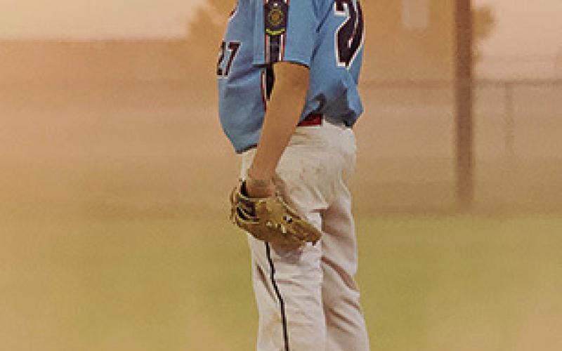(Photo by Richae Malara) Freshman Tyler Shultz gets the sign during a contest against Kimball on Friday, June 21. The Western Nebraska winds were strong on this evening, moving the dirt into the air and creating tough conditions to play baseball.
