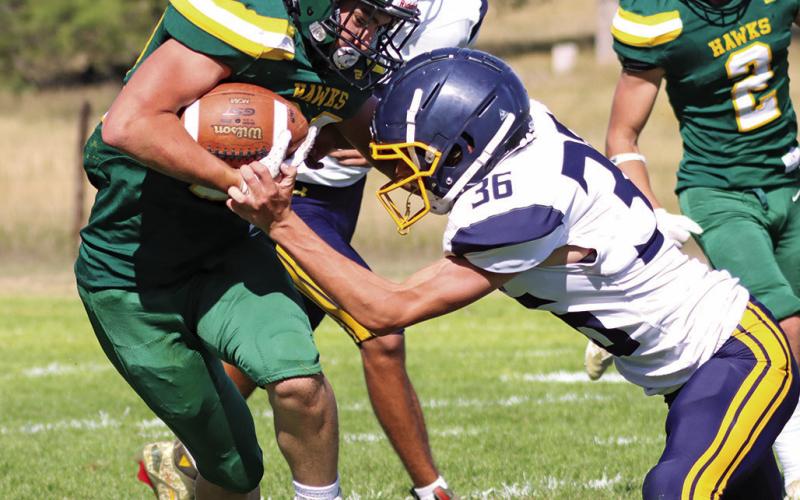 Photo by Scott Bidroski Senior Dylan Raymer absorbs the contact and sheds the Paxton defender. Raymer led the Hawks with 131 yards rushing and scored 2 touchdowns in the 28-14 Hawks win.