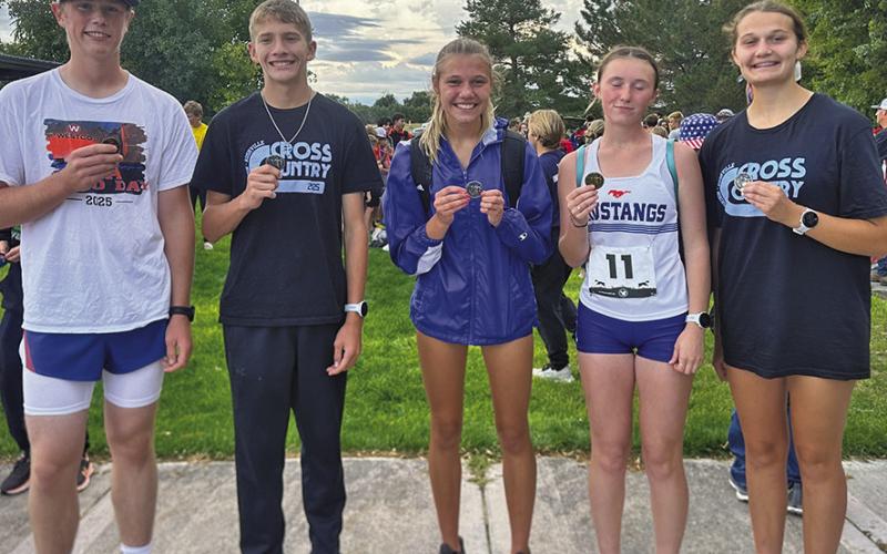 (Photo by Amy Schmidt) Luke Laws, Robert Moore, Brittney Dehning, Kynsleigh Krebs, and Ashlyn Dehning show off the hardware their received from the Run the Rocks Invite in Bridgeport on Tuesday, Sept. 16.