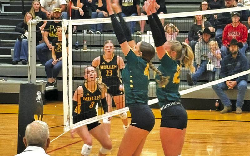 Photo by Jim Varvel Senior Mya Turman and sophomore Devyn Young go up for the block against Mullen on Friday, Sept. 5.
