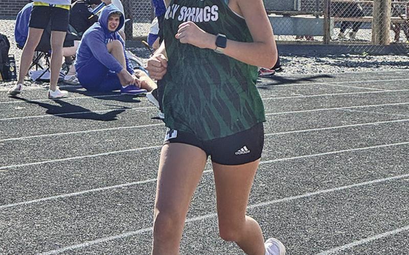 (Photo by Jessie Anderson) Freshman Tabby Schiaffo rounds the corner during the Mitchell Invite on Thursday, April 9.
