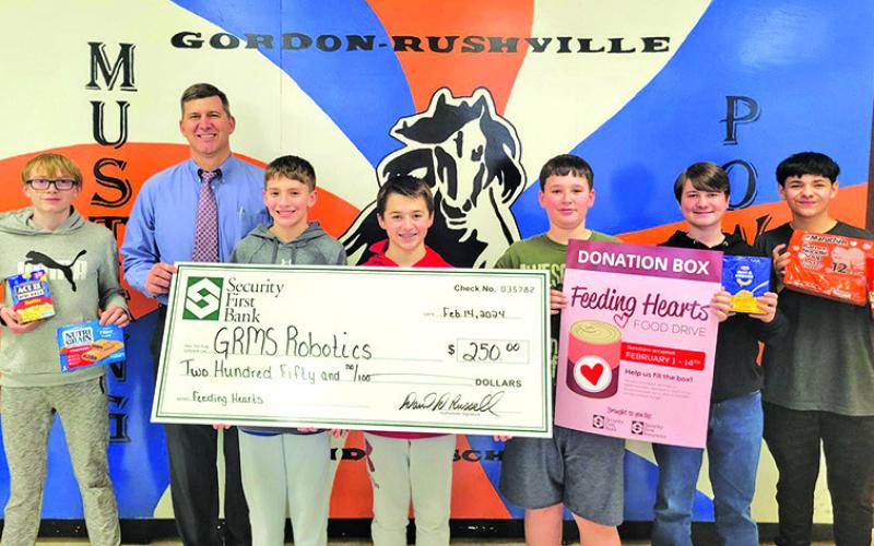 Courtesy Photo Security First Bank President David Russell presents a check to the Gordon-Rushville Middle School Robotics Program in support of their Little Food Pantry. The funds raised are from the Feeding Hearts program hosted by Security First Bank.
