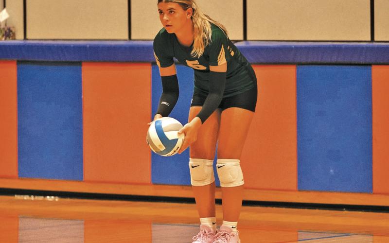 (Photo by Richae Malara) Senior Julia Russell lines up her serve during the Gordon-Rushville Tournament. Russell and the Hawks stayed hot this past week with wins over Hyannis and Bayard.