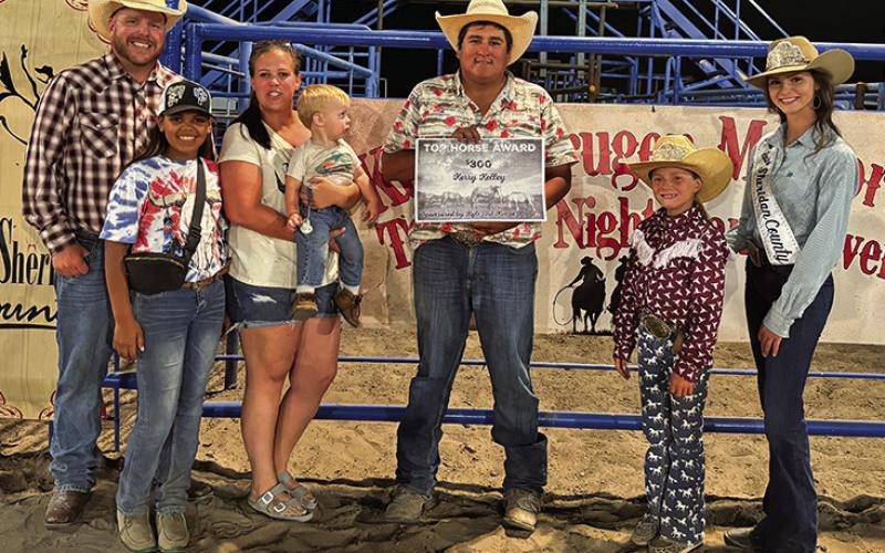 Photo by Courtney Ostrander Right: Patrick Jumping Eagle, center, received the Top Horse Award during the Tuesday Night festivities. The award is sponsored by the Kruger family (left).