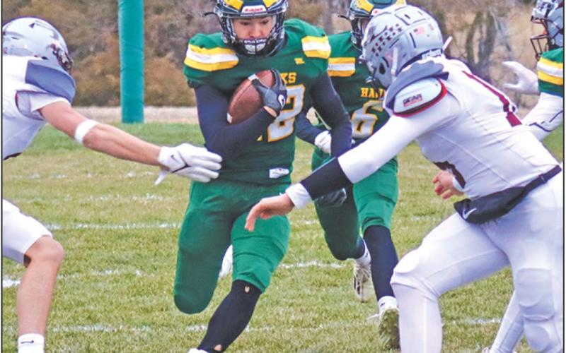 Photo by Scott Bidroski Senior Dylan Raymer pushes for a seam against the Silver Lake defense in the Hazvks 38-30 win over the Mustangs in the second round of the State 6-Man Playoffs on Friday, November 8, 2024.