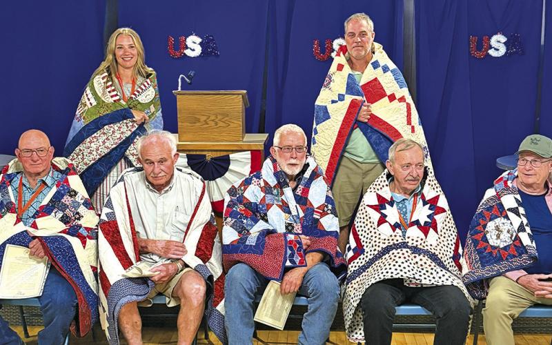 Courtesy Photo Seven Veterans received their Quilts of Valor during the ceremony and two more received theirs at their home during the Rushville All-School Reunion. Those pictured include: Front row (LR) Jack Beguin, Ron Coomes, Tim White, Ron Smith, and Tim Moss. Back row (L-R) Michel Beguin Long and Brad Krotz.