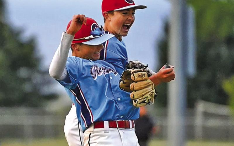 (Photo by Richae Malara) Eighth graders Liam Keracik and Khai Janssen celebrate a big strikeout that finished an inning against Orchard Tri-County.