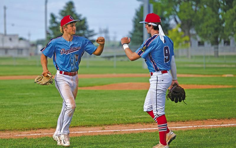 (Photo by Marlee Keracik) Tripp Buettner (#00) meets with teammate Bronson Freeseman (#9) following an inning during the Regulator Senior win, 15-6 on Sunday, June 15.