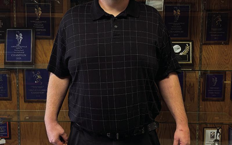 Photo by Tessa Hurlburt Darren Probst, the new Athletic Director for GRHS, standing in front of the trophy case at GRHS. He hopes to see the Mustangs have successful seasons this year.