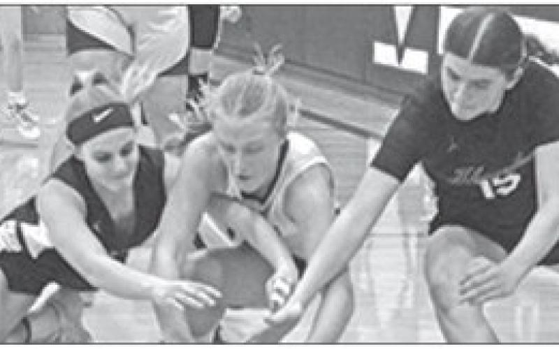 Photo by Jessica Mintken Hawks sophomores Andi Twarling (left) and Julia Russell (right) dive for the loose ball against Garden County.