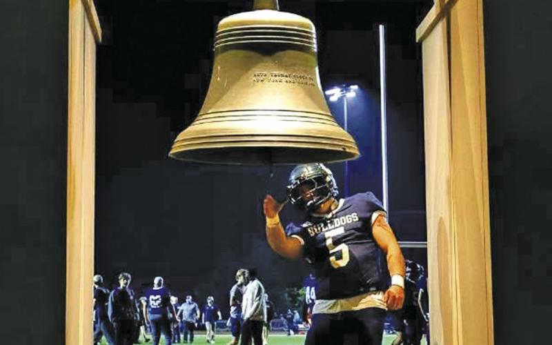 (Photo by Ben Meyer) Concordia University senior and 2022 Hay Springs High School graduate Logan DeCoste rings the bell in celebration of a home football game victory in Seward, Neb. DeCoste is entering his fourth and final season as a Bulldog football student-athlete.