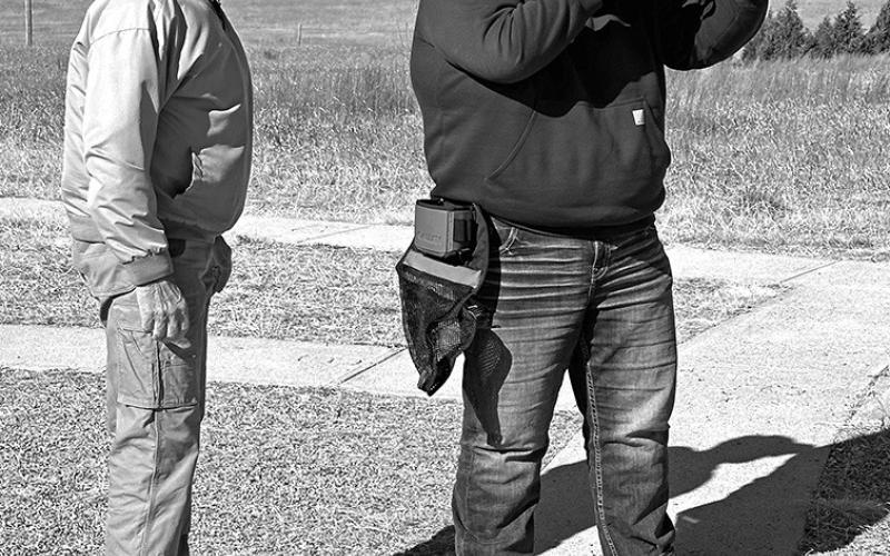 Photo by Rodney Beguin Junior Niobrara Trapshooting Coach Buster Kearns instructs 4th year team member Ethan Bourne at the shooting range.