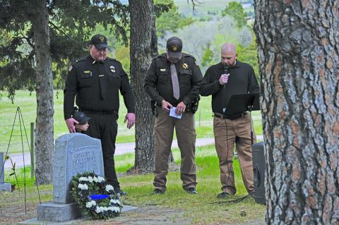 (Photo by Courtney Ostrander) Gordon Police Chief Clay Heath, Sheridan County Sheriff Jeff Brewer, and Jason Gantz bow their heads in prayer at the Gordon Cemetery in honor of Police Memorial Week.