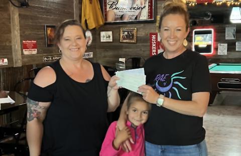 (Courtesy Photo) Smitty’s Place owner Misty Belsky (left) presents a check to Julie and Sloane Linders in benefit of the organization McKenna’s Rae of Hope.