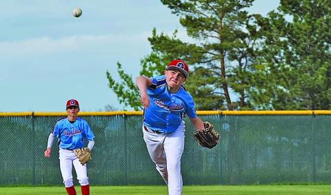 (Photo by Richae Malara) Eighth grader Liam Keracik delivers a pitch against the Chadron Juniors while fellow eighth grader Khai Janssen readies himself at shortstop. While not in high school yet, these two young men are key components of the Juniors team. 