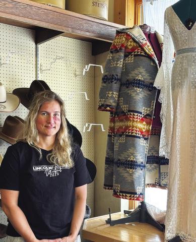 Photo by Lisa Hare Marie Nelson, part owner of the new “Many Irons” clothier store, stands near two of her most recent custom designs. Located in the building which ,for more than a century, served Gordon area customers as Morris Clothing, the new business will offer a variety of new services.