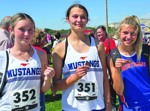 Photo by Amy Schmidt Some hardware came home on the Mustang bus following their races at Red Rocks Amphitheater in Gering, Neb. From left to right, Kynsleigh Krebs, Ashlyn Dehning, and Brittany Dehning all placed in the top ten during the days races.