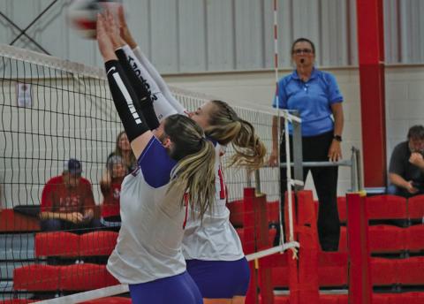 (Photo by Michele Heck) Seniors Kirsten Heck and Taleigh Starr block the kill attempt from the Kimball Longhorns. Heck, Starr, and the Mustangs finished their day with a 1-1 record to start the season.