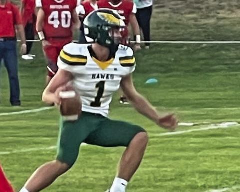 Photo by Jessica Mintken Senior Dylan Young looks for an open receiver against Potter-Dix on Friday, September 13. The Hawks would cruise to a big victory, 88-53.