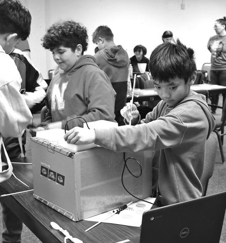 Photo by Chabella Guzman Performing laparoscopic surgery, Jackson Freeling, front right, keeps an eye on the screen to guide him. Meanwhile, Giovanni Gomez, back right, and others get their tools ready for surgery.