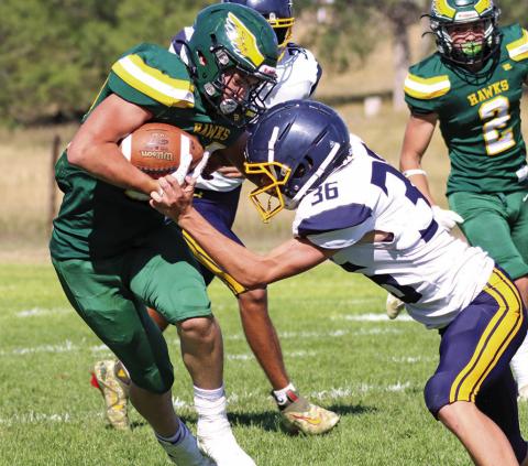 Photo by Scott Bidroski Senior Dylan Raymer absorbs the contact and sheds the Paxton defender. Raymer led the Hawks with 131 yards rushing and scored 2 touchdowns in the 28-14 Hawks win.