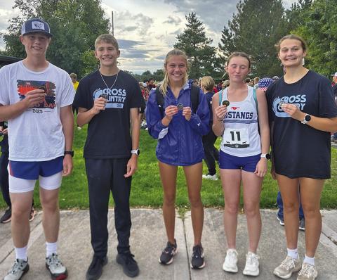 (Photo by Amy Schmidt) Luke Laws, Robert Moore, Brittney Dehning, Kynsleigh Krebs, and Ashlyn Dehning show off the hardware their received from the Run the Rocks Invite in Bridgeport on Tuesday, Sept. 16.