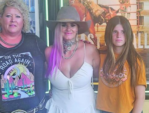 (Courtesy Photo) At the premiere event for East of Wall, Gordon Livestock owner Patsy Tines (left) takes a photo with the stars of the film, Tabatha Zimiga (center) and Porshia Zimiga (right).