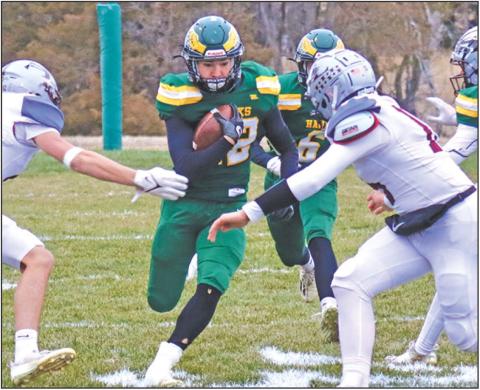 Photo by Scott Bidroski Senior Dylan Raymer pushes for a seam against the Silver Lake defense in the Hazvks 38-30 win over the Mustangs in the second round of the State 6-Man Playoffs on Friday, November 8, 2024.
