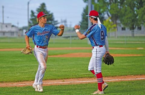 (Photo by Marlee Keracik) Tripp Buettner (#00) meets with teammate Bronson Freeseman (#9) following an inning during the Regulator Senior win, 15-6 on Sunday, June 15.