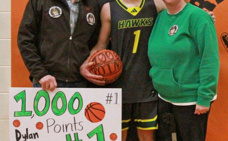 (Photo by Bev Lee) Adam and Jennifer Young take a photo postgame with their son, Dylan Young, following his scoring of his 1,000th career point as a Hawk.